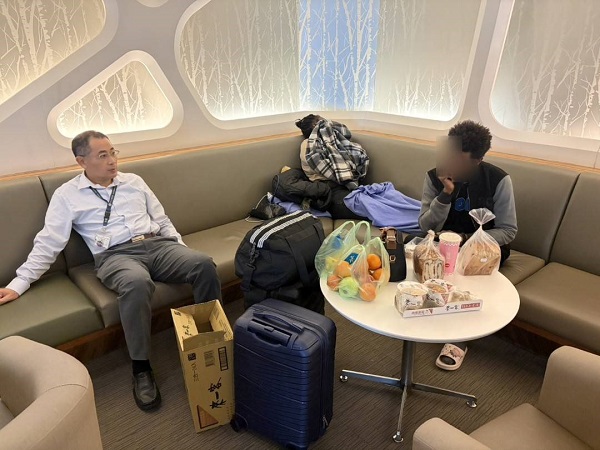 移民署國境事務大隊特殊勤務隊隊長康慶年(左)關懷海地旅客生活狀況，並主動提供餐食，以實際行動傳遞溫暖。