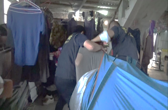 圖1：失聯移工躲帳篷，遭專勤隊幹員強力帶出